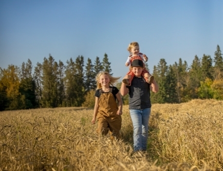 children walking through a wheat field