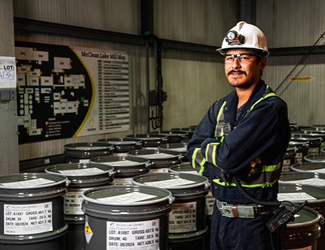 man in safety gear next to barrels